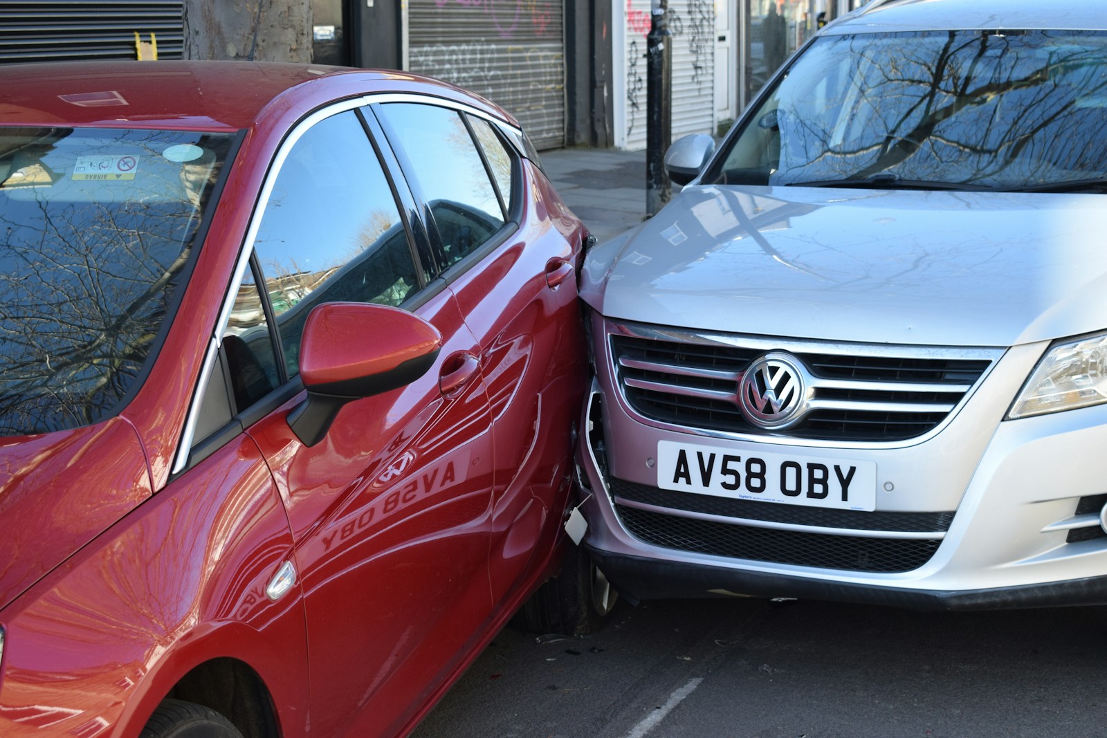 two cars parked next to each other in a parking lot auto